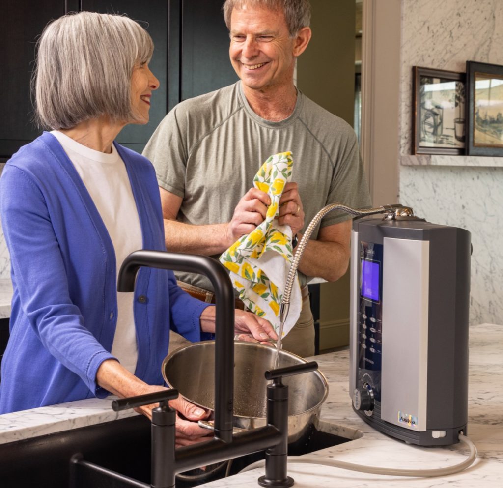 man in woman in kitchen filling up pot with alkaline water